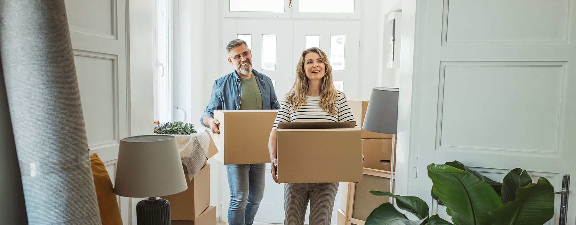 Mature couple moves in to their new home, unpacking boxes and enjoying the time together.